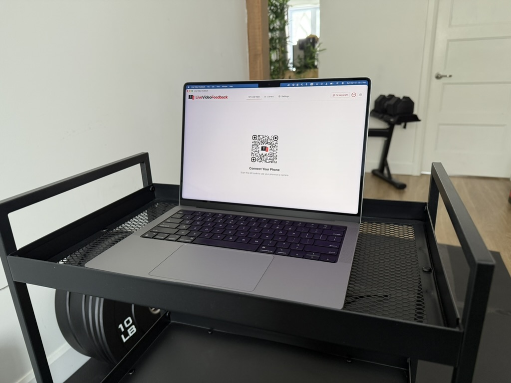 Laptop showing Live Video Feedback phone connect screen in a home exercise setup