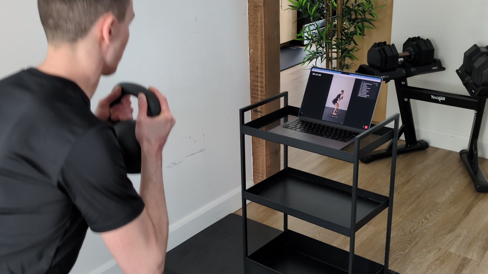 Watching yourself live on a laptop while exercising during a kettlebell movement
